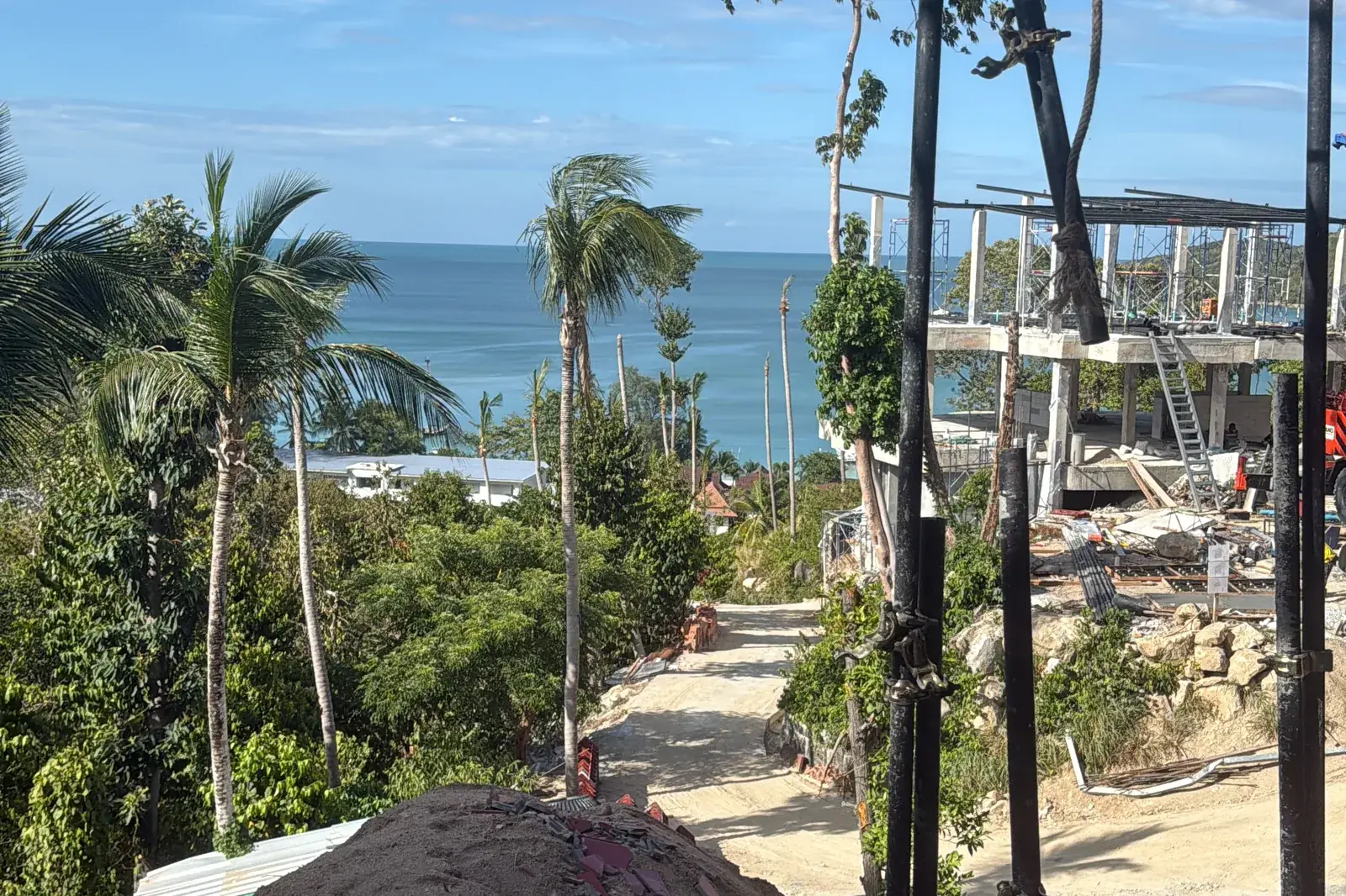 View from a new floor slab at Gaia Residence down the access road to Chaloklum Bay, September 2026